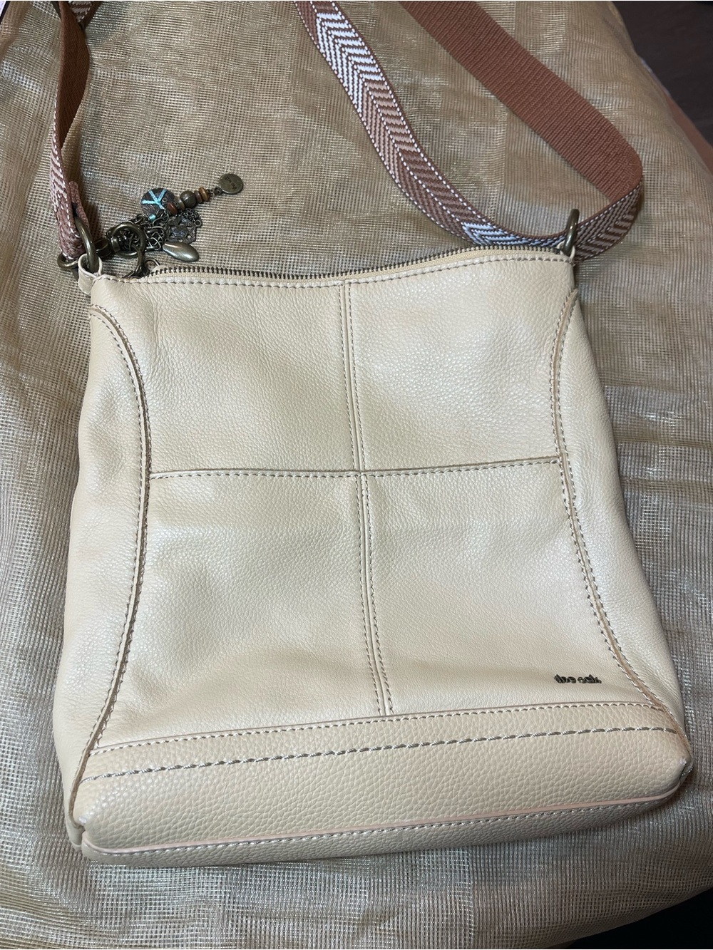 The Sak Cream Pebbled Leather Crossbody Bag with Patterned Strap